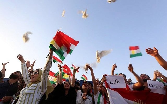 Des Kurdes irakiens libèrent des colombes durant une manifestation à l'aéroport d'Irbil, dans la capitale de la région autonome kurde en Irak, après que le gouvernement central a ordonné l'arrêt pour une période indéterminée de tous les vols étrangers vers et depuis le Kurdistan irakien, le 29 septembre 2017 (Crédit : AFP Photo/Safin Hamed)