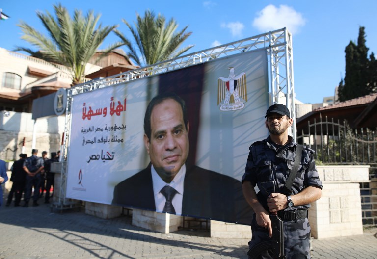 Un garde de sécurité du Hamas devant un portrait du président égyptien Abdel Fattah al-Sissi, près des bureaux gouvernementaux de Gaza Ville, le 3 octobre 2017. (Crédit : Mohammed Abed/AFP)