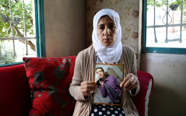 Manal al-Sayed tient une photographie de son fils, Hisham, retenu captif par le groupe terroriste du Hamas depuis 2016. (Crédit : Yoav Lemmer/AFP)