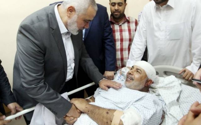 Ismail Haniyeh, le chef du Hamas, au chevet de Tawfiq Abou Naim à l'hôpital Shifa de Gaza Ville, dans la bande de Gaza, le 27 octobre 2017. (Crédit : Mohammad Austaz/Hamas)