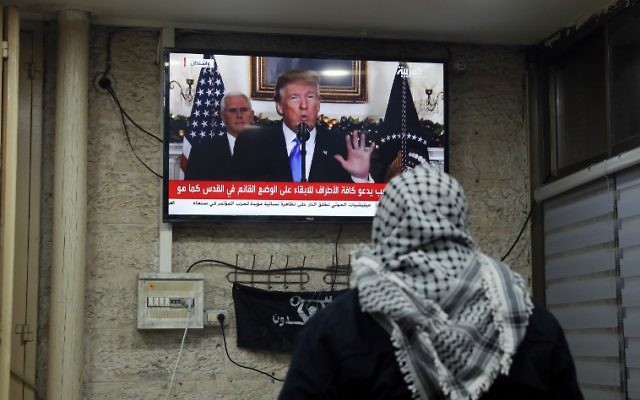 Une photo prise le 6 décembre 2017 montre un Palestinien regardant une allocution prononcée par le président américain Donald Trump, où il annonce la reconnaissance américaine de Jérusalem comme la capitale d'Israël, dans un café à Jérusalem (Crédit : Ahmad GHARABLI / AFP)