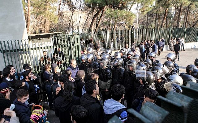 Des étudiants iraniens affrontent la police à l'université de Téhéran durant une manifestation, le 30 décembre 2017. (Crédit : AFP PHOTO / STR)
