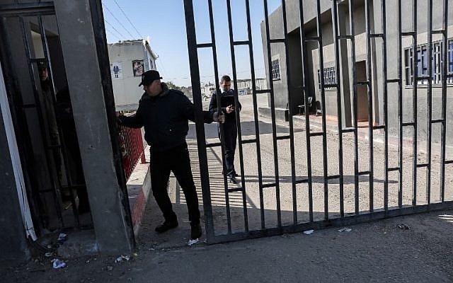 Un gardien de la sécurité palestinien ferme la porte du carrefour de Kerem Shalom qui a été le principal passage pour les biens qui pénètrent dans Gaza après sa fermeture par Israël suite à la découverte de tunnels de contrebande sous ce poste frontalier à Rafah, dans le sud de la bande de Gaza, le 14 janvier 2018 (Crédit :AFP PHOTO / SAID KHATIB)