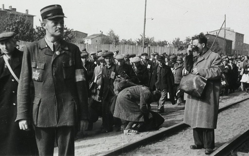 Le photographe du ghetto de Łódź, Mendel Grossman, qui photographie en cachette la déportation des Juifs du ghetto de Łódź. La photo a été prise par l'assistant de Grossman, Aryeh Ben-Menachem.
(Crédit : Archives Yad Vashem)