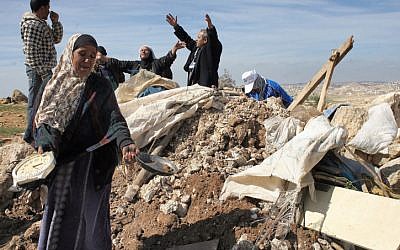 Les Palestiniens tentent de récupérer des objets dans les décombres d'une maison après avoir été détruit par des tracteurs de Tsahal près du village de Susya en Cisjordanie en 2011 (Crédit : Najeh Hashlamoun / Flash90)