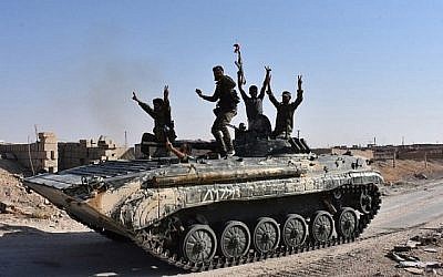 Les forces gouvernementales syriennes se réjouissent dans la ville de Deir Ezzor, dans l'est de la Syrie, le 11 septembre 2017, alors qu'elles continuent d'avancer avec la couverture aérienne russe dans l'offensive contre le groupe terroriste islamique. (AFP Photo/George Ourfalian)