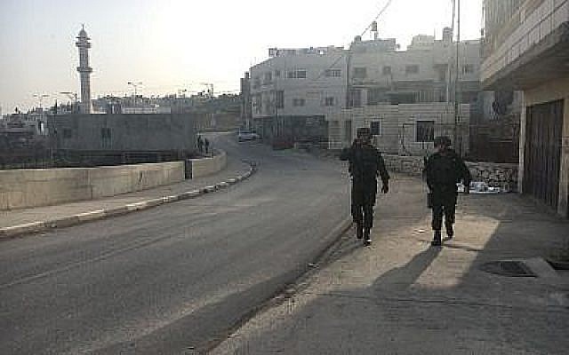 Les soldats israéliens marchent dans la ville palestinienne de Halhul, au nord de Hébron, après qu'un habitant a poignardé un gardien de la sécurité lors d'un attentat terroriste dans une implantation voisine, le 7 février 2018 (Crédit : Armée israélienne)
