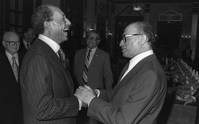 Le Premier ministre israélien Menachem Begin (à droite) et le président égyptien Anouar el-Sadate rient ensemble à l'hôtel King David, le 19 novembre 1977 (Crédit : archives Ya'akov Sa'ar / GPO)