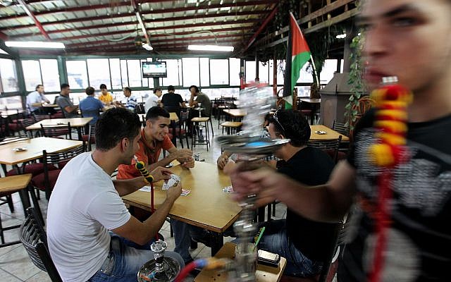 Des jeunes palestiniens fument des narguilés et jouent aux cartes au café Sultan à Ramallah, en Cisjordanie, le 11 septembre 2011 (Crédit : Nati Shohat / Flash90)