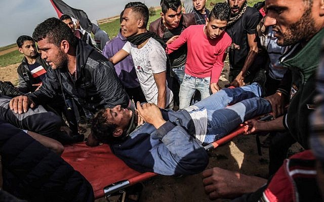 Des Palestiniens aident à évacuer un manifestant blessé sur une civière lors d'affrontements avec les troupes israéliennes près de Khan Yunis, près de la frontière entre Israël et la bande de Gaza, le 2 mars 2018. (AFP PHOTO / DIT KHATIB)