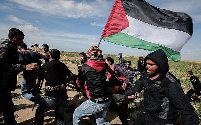 Des Palestiniens aident à évacuer un manifestant blessé lors d'affrontements avec les troupes israéliennes, près de Khan Younès, près de la barrière frontalière entre Israël et le sud de la bande de Gaza, le 9 mars 2018. (AFP PHOTO / DIT KHATIB)
