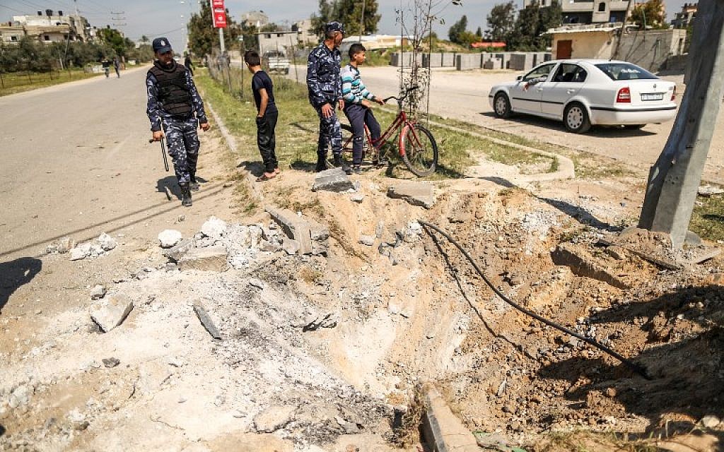 Des membres des forces de sécurité du Hamas inspectent le cratère laissé sur le site d'une explosion qui a visé le convoi du Premier ministre palestinien lors de sa visite dans la bande de Gaza le 13 mars 2018. (AFP/MAHMUD HAMS)