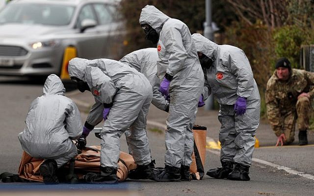Des militaires britanniques portant une combinaison de protection travaillent pour évacuer un véhicule lié à l'attaque de l'agent neurotoxique du 4 mars à Salisbury, dans le sud-est de l'Angleterre, le 14 mars 2018. (Adrian DENNIS/AFP)