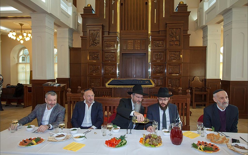 Des dirigeants de la communauté juive de Tomsk entourent le grand rabbin de Russie Berel Lazar lors d'un déjeuner à la synagogue principale de Tomsk avant la restitution de la synagogue cantoniste, le 1er février 2018. (Courtesy Chabad de Tomsk)