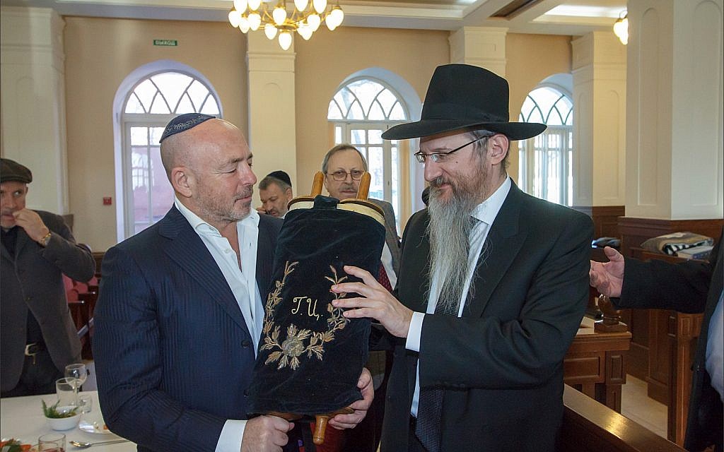Le grand rabbin de Russie Berel Lazar, à droite, avec Baruch Ramatsky, tenant le rouleau de la Torah, que la famille de Ramatsky a gardé caché pendant les 90 dernières années, à l'intérieur de la synagogue de Tomsk, le 1er février 2018. (Courtesy Chabad de Tomsk)