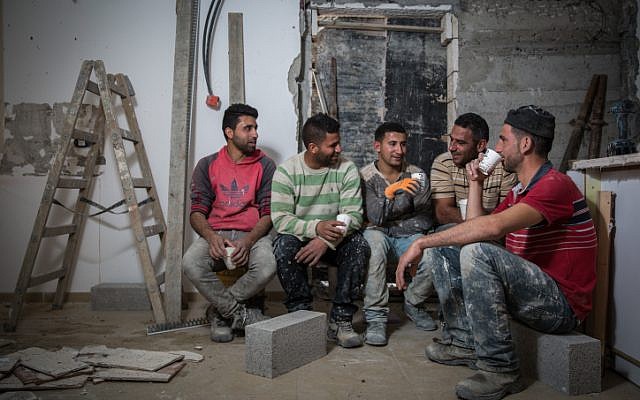 Des ouvriers en bâtiment palestiniens du village d'Abadiya en Cisjordanie, pendant une pause-café dans une maison en cours de rénovation dans l'implantation juive d'Alon, au sud de Jérusalem, le 16 février 2016. (Crédit : Hadas Parush / Flash90)