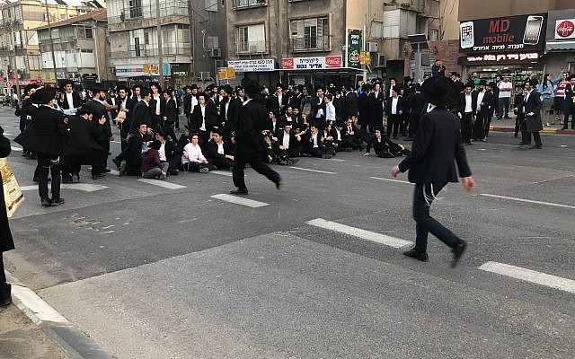 Des manifestants ultra-orthodoxes bloquent une route à Bnei Brak alors qu'ils manifestent contre le projet de l'armée, le 22 mars 2018 (Crédit : Porte-parole de la police)