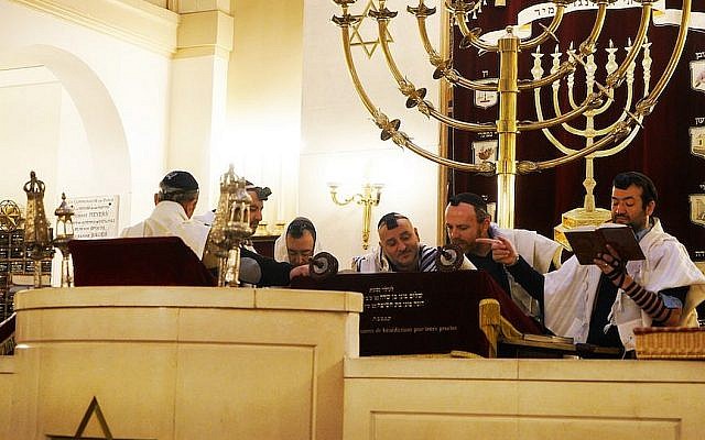Le rabbin Michael Azoulay, (deuxième à partir de la droite), lisant la Torah avec des fidèles à la synagogue de Neuilly-sur-Seine, le 11 décembre 2017. (Crédit : Cnaan Liphshiz / JTA)