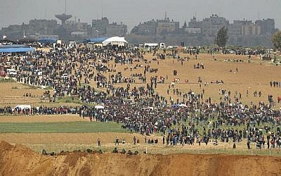Une photo prise le 30 mars 2018 du kibboutz israélien sud de Nahal Oz de l'autre côté de la bande de Gaza montre des Palestiniens participant à une manifestation pour commémorer la Journée de la Terre(Crédit : AFP PHOTO / Jack GUEZ)
