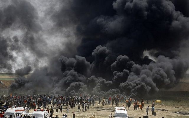 Des Palestiniens brûlent des pneus à la frontière avec Israël, à l'est de Jabalia, dans le centre de la ville de Gaza, lors d'une manifestation le 13 avril 2018 (Crédit: AFP PHOTO / MOHAMMED ABED)