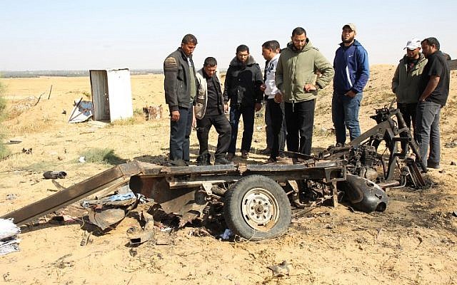 Des Palestiniens observent les débris d'un véhicule en tuk tuk sur le site d'une explosion à l'est de Rafah, dans le sud de la bande de Gaza, le 14 avril 2018. Quatre terroristes du Jihad islamique sont morts dans l'explosion, à quelques mètres de la frontière avec Israël (Crédit : AFP / SAID KHATIB)