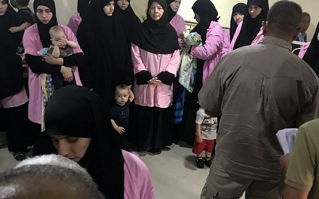 Une photo prise le 29 avril 2018 au tribunal pénal central de Bagdad, la capitale irakienne, montre des femmes russes condamnées à la prison pour avoir rejoint le groupe de l'État islamique debout avec des enfants dans un couloir. (Crédit : AFP/ Ammar Karim)