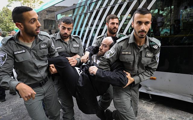 Des hommes juifs ultra-orthodoxes se heurtent à la police lors d'une manifestation contre l'autopsie d'un bébé qui s'est noyé la veille à Ashdod, à Kikar HaShabbat, à Jérusalem, le 3 avril 2018. (Noam Revkin Fenton/Flash90)