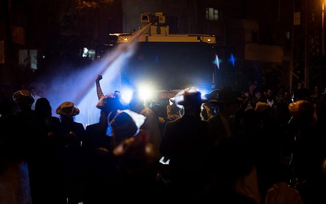 La police israélienne utilise un canon à eau contre les manifestants juifs ultra-orthodoxes lors d'une manifestation devant le bureau de recrutement de l'armée à Jérusalem, à la suite de l'arrestation d'une femme juive ultra-orthodoxe. 15 avril 2018. (Yonatan Sindel/Flash90)