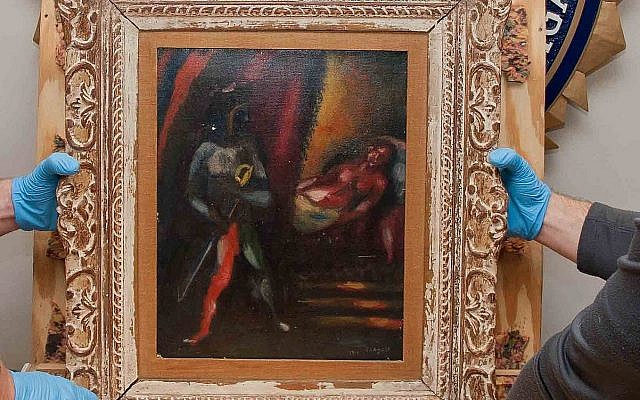 un agent spécial du FBI spécialisé dans le marché de l'art tient un tableau volé de Marc Chagall, 'Othello et Desdémone,' avant de le rendre à ses propriétaires, près de 30 ans après qu'il a été dérobé. (Crédit : FBI)