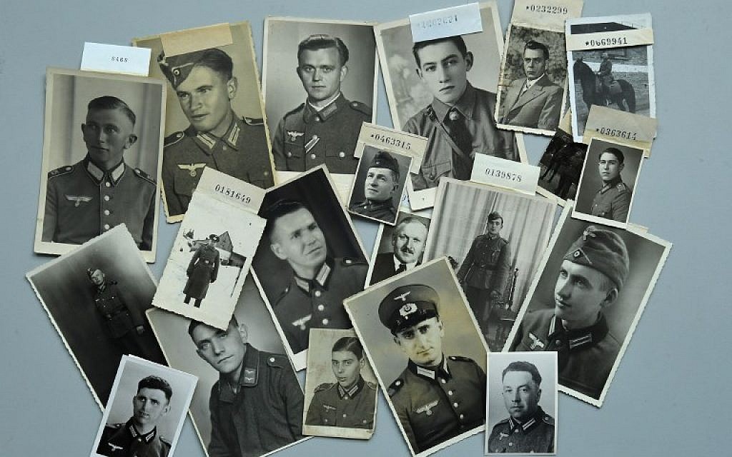 Des photos de soldats allemands portés-disparus pendant la Seconde guerre mondiale sur une table de la Croix Rouge allemande, à Munich, dans le sud de l'Allemagne, le 9 avril 2018 (Crédit :   / AFP PHOTO / Christof STACHE / )