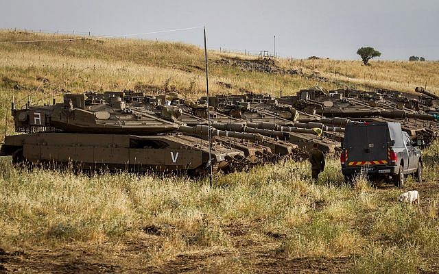Soldats israéliens observés à côté de chars près de la frontière israélo-syrienne sur le plateau du Golan le 10 mai 2018. (Basel Awidat/Flash90)