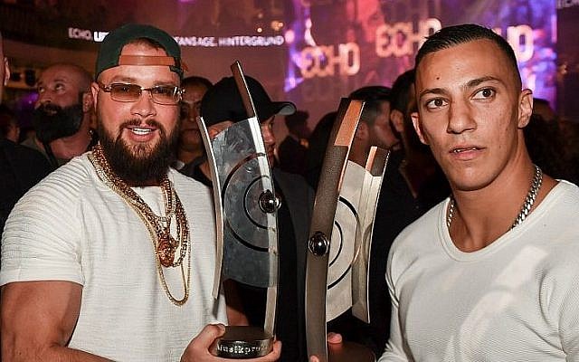 Les rappeurs allemands Kollegah, à gauche, et Farid Bang posent avec leur  trophée de l'Echo obtenu dans la catégorie hip/hop musique urbaine, le 12 avril 2018 (Crédit : AFP PHOTO / dpa / Jens Kalaene0