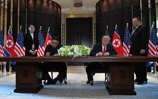 Le président américain Donald Trump (2e à droite) et le dirigeant nord-coréen Kim Jong Un (2e à gauche) signent des documents alors que le secrétaire d’État américain Mike Pompeo (à droite) et la sœur du dirigeant nord-coréen Kim Yo Jong (à gauche) assistent à une cérémonie de signature lors du sommet États-Unis-Corée du Nord à l’hôtel Capella sur l’île de Sentosa, à Singapour, le 12 juin 2018. (Saul Loeb/AFP)