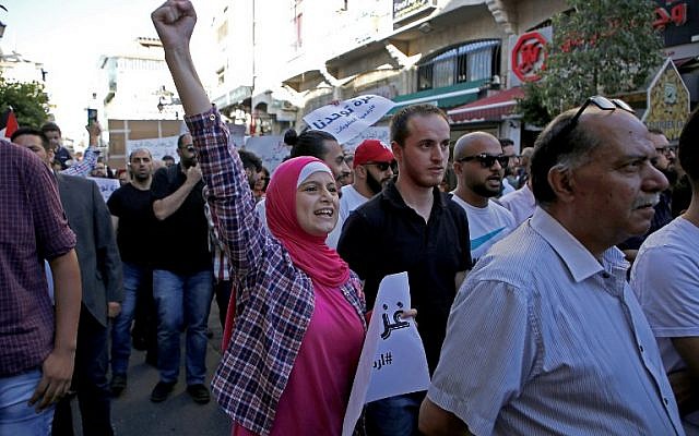 Les Palestiniens participent à une manifestation appelant à la levée des sanctions contre la bande de Gaza, dans la ville de Ramallah en Cisjordanie, le 23 juin 2018. (Crédit : AFP / ABBAS MOMANI)