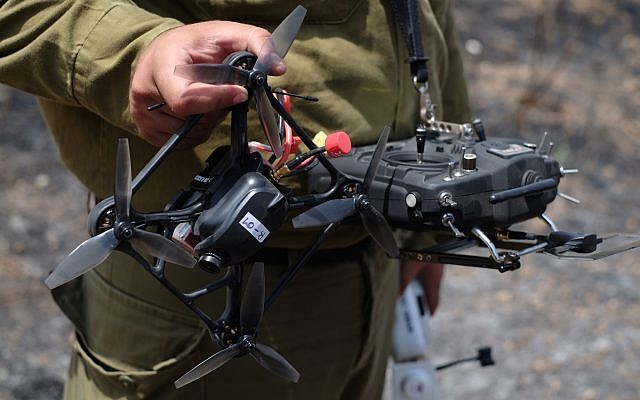 Un soldat de Tsahal montre son drone et sa télécommande dans un champ incendié par des cerfs-volants de la bande de Gaza le 7 juin 2018. (Judah Ari Gross/Times of Israel)
