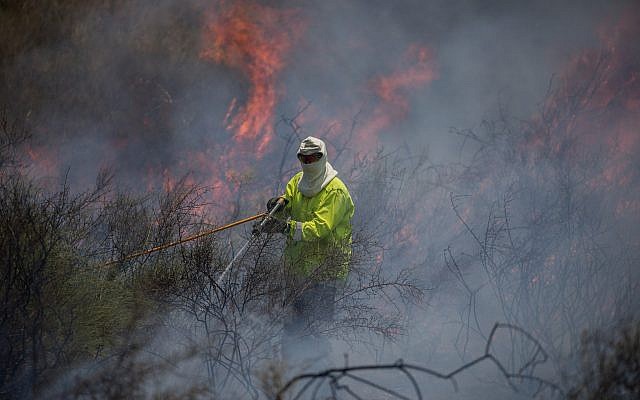Des pompiers éteignent un incendie dans un champ causé par des cerfs-volants pilotés par des Palestiniens depuis la bande de Gaza, près de la frontière avec Israël, le 5 juin 2018. (Yonatan Sindel/Flash90)