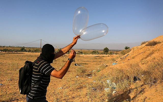 Un Palestinien prépare un ballon qui sera attaché à des matériaux inflammables puis sera envoyé par les airs vers Israël près de la frontière israélo-gazanaise, à Rafah, dans le sud de la bande de Gaza, le 17 juin 2018. (Abed Rahim Khatib/Flash90)