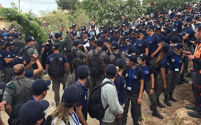 Des policiers et des agents de la police des frontières à l'avant-poste de Netiv Haavot dans la zone du Gush Etzion en Cisjordanie lors de la démolition de 15 maisons construites illégalement, le 12 juin 2018. (Luke Tress/Times of Israel)