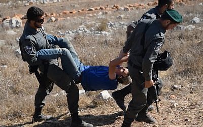 Photo d'illustration : La police des frontières emmène un membre des "Jeunes des Collines" durant l'évacuation d'un avant-poste illégal dans le nord de la Cisjordanie. (Crédit: Zman Emet, Kan 11)