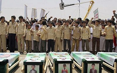Des enfants yéménites expriment leur colère contre Riyad et Washington alors qu'ils participent à des funérailles massives d'enfants tués dans une frappe aérienne la semaine précédente par une coalition dirigée par les Saoudiens, ici dans la ville de Saada, au nord du Yémen, le 13 août 2018. (AFP)