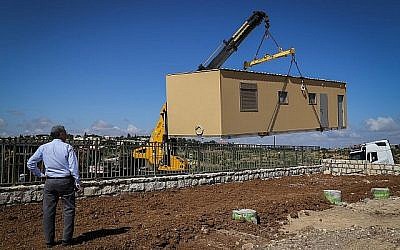 Image d’illustration : une grue installe un bungalow dans la nouvelle implantation d'Etzion, en Cisjordanie, destinée à réinstaller les évacués de l'avant-poste de Netiv Ha'avot, le 9 mai 2018. (Gershon Elinson / Flash90)