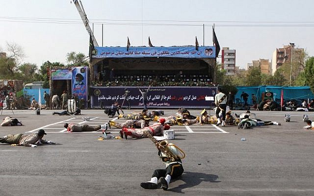 Des soldats blessés au sol sur la scène d'un attentat survenu pendant une parade militaire marquant l'anniversaire de la guerre de 1980-1988 avec l'Irak de Saddam Hussein, le 22 septembre 2018 (Crédit :  / AFP PHOTO / ISNA / ALIREZA MOHAMMADI)