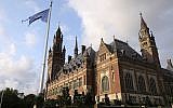 Le drapeau des Nations unies à côté de la Cour internationale de justice de la Haye, aux Pays-Bas. (Crédit : AP Photo/Mike Corder)