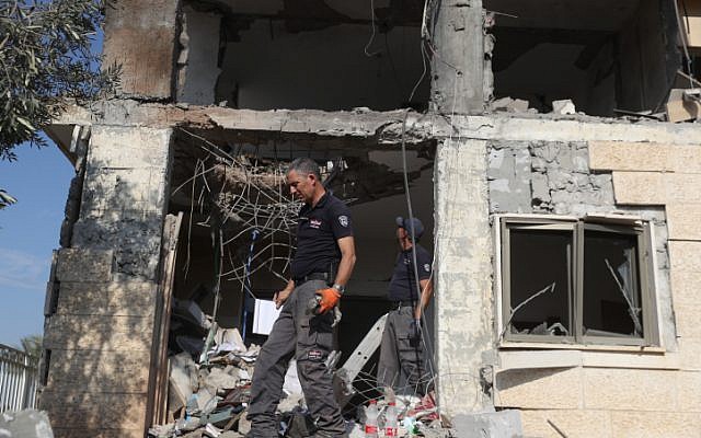 Les forces de sécurité israéliennes inspectent une maison frappée par une roquette lancée depuis la bande de Gaza à Beer Sheva, dans le sud d'Israël, le 17 octobre 2018 (Crédit : Yonatan Sindel/Flash90)