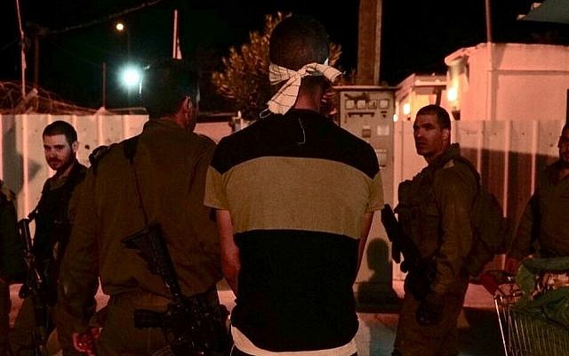 Les soldats israéliens arrêtent l'auteur présumé d'un attentat à l'arme blanche commis contre un soldat réserviste aux abords d'une base de l'armée israélienne dans le nord de la Cisjordanie, le 12 octobre 2018 (Crédit : Nasser Ishtayeh/Flash90)