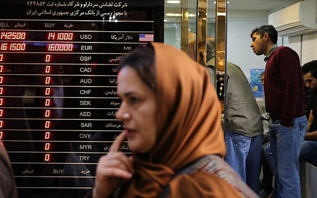 Une femme passe devant un bureau de change dans le grand bazar de la capitale iranienne, le 3 novembre 2018. (Crédit : ATTA KENARE / AFP)