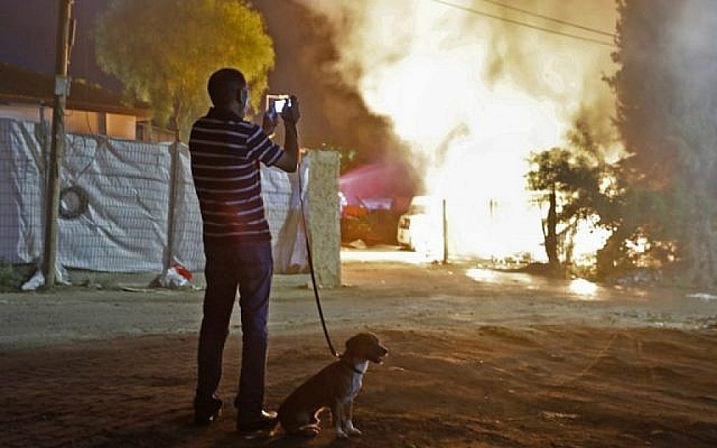 Un homme observe un bâtiment qui a été incendié après avoir été touché par une roquette tirée depuis la bande de Gaza, dans la ville de Sdérot, dans le sud d'Israël, le 12 novembre 2018. (Crédit : Menahem KAHANA / AFP)