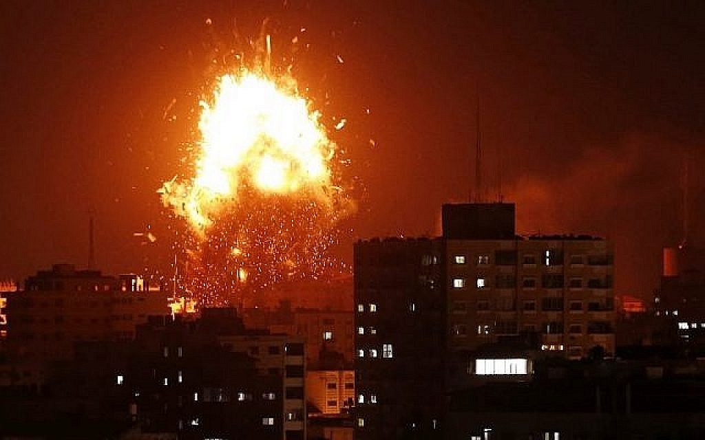 Une boule de feu au-dessus du bâtiment abritant la chaîne de télévision Al-Aqsa dirigée par le Hamas dans la bande de Gaza lors d'une frappe aérienne israélienne le 12 novembre 2018. (Crédit : MAHMUD HAMS / AFP)