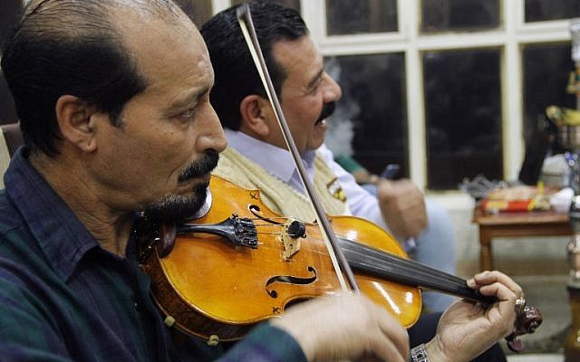 Des irakiens jouent et écoutent de la musique dans un café de Mossoul, le 6 novembre 2018. (Crédit : Zaid AL-OBEIDI / AFP) Waleed AL-KHALID / AFP)
