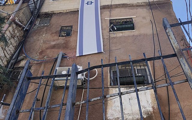 Un drapeau israélien est accroché sur un immeuble appartenant à Ateret Cohanim dans le quartier Batan al-Hawa de Silwan, Jérusalem-Est, le 31 juillet 2018. (Crédit : Sue Surkes/Times of Israel)